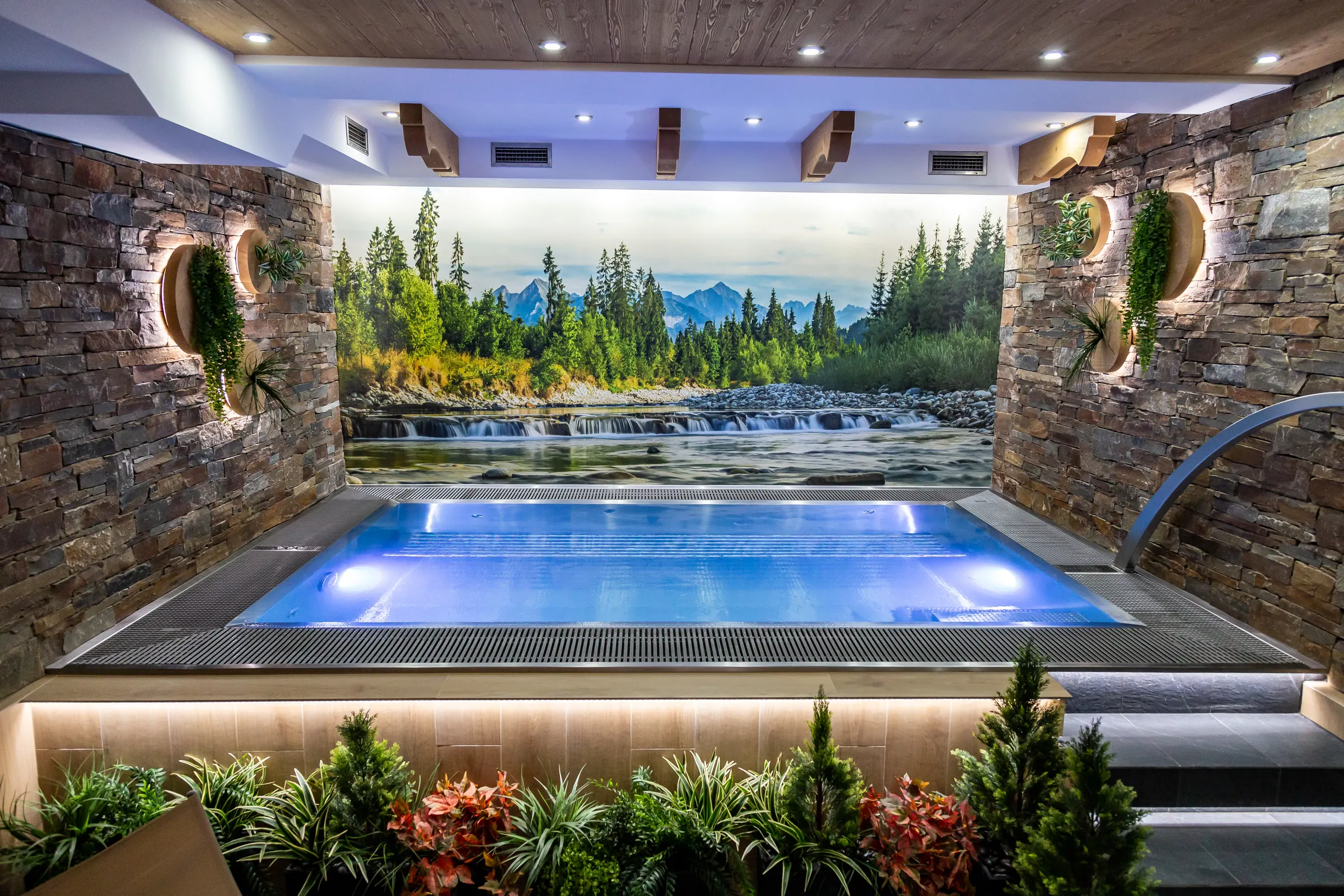 Vírivý bazén wellness Resortu Kamzík s maľbou Tatier na stene a kamenným obkladom